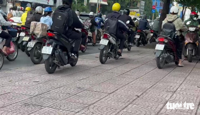 Ho Chi Minh City rush hour sends 40+ motorbikes onto sidewalks within minute- Ảnh 2. Ho Chi Minh City rush hour sends 40+ motorbikes onto sidewalks within minute- Ảnh 2.