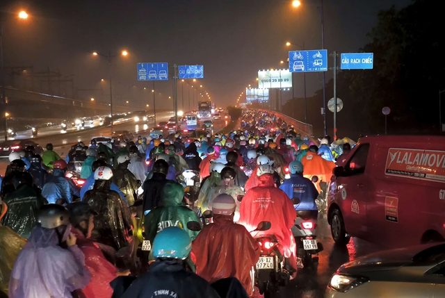 Heavy rain paralyzes Ho Chi Minh City traffic, forces commuters onto sidewalks- Ảnh 5. Heavy rain paralyzes Ho Chi Minh City traffic, forces commuters onto sidewalks- Ảnh 5.