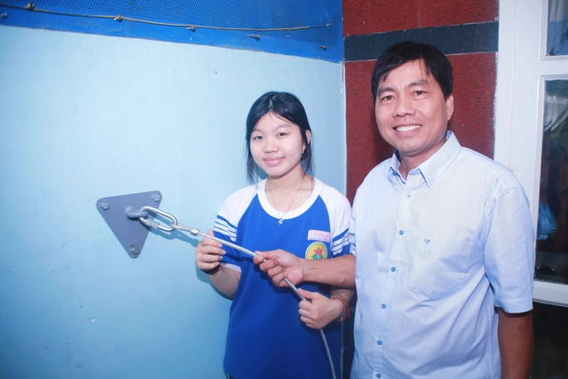 Father, daughter in Ho Chi Minh City invent diagonal cable escape system for high-rise fires - Ảnh 2.