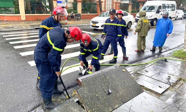 Da Nang policeman climbs into storm drain to recover phone for foreign tourist - Ảnh 1.