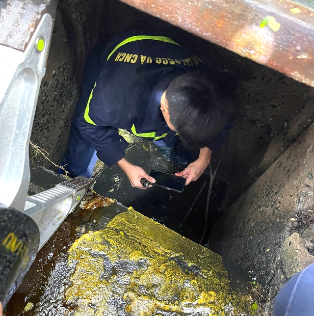 Da Nang policeman climbs into storm drain to recover phone for foreign tourist - Ảnh 2.