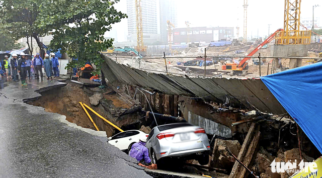 Sinkhole swallows 2 cars in downtown Da Nang - Ảnh 1.