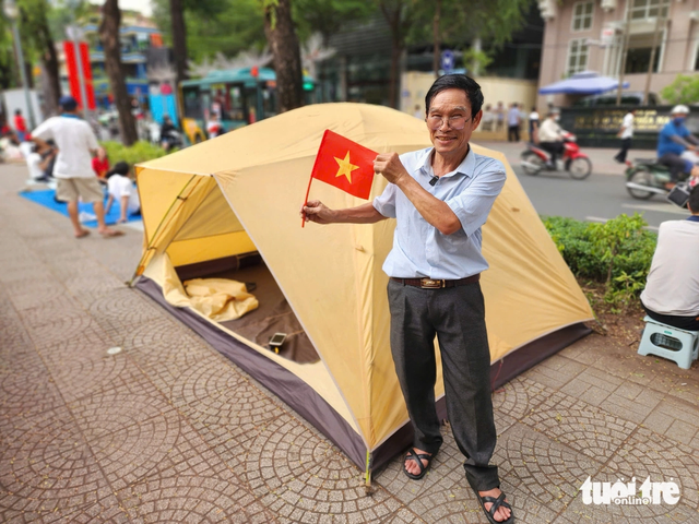 Before sunset, people lay tarps, pitch tents to claim spots for April 30 parade in Ho Chi Minh City - Ảnh 1.