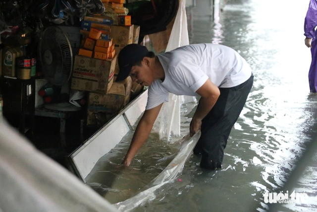 Heavy rains flood Ho Chi Minh City streets, dislodge drains, disrupt traffic - Ảnh 1. Heavy rains flood Ho Chi Minh City streets, dislodge drains, disrupt traffic - Ảnh 1.