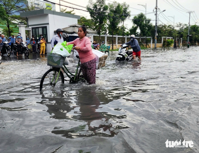Rain floods street outside suburban Ho Chi Minh City hospital, stranding patients - Ảnh 2.