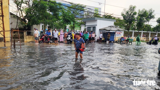 Rain floods street outside suburban Ho Chi Minh City hospital, stranding patients - Ảnh 1.