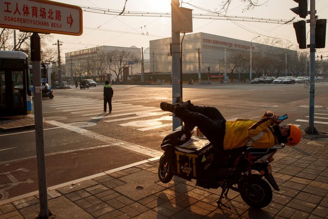 Beneath China's resilient economy, a life of pay cuts and side hustles - Ảnh 1. Beneath China's resilient economy, a life of pay cuts and side hustles - Ảnh 1.