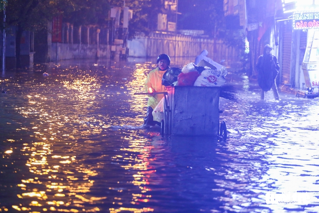 Heavy rains flood Hanoi streets again, residents struggle to get home - Ảnh 2.