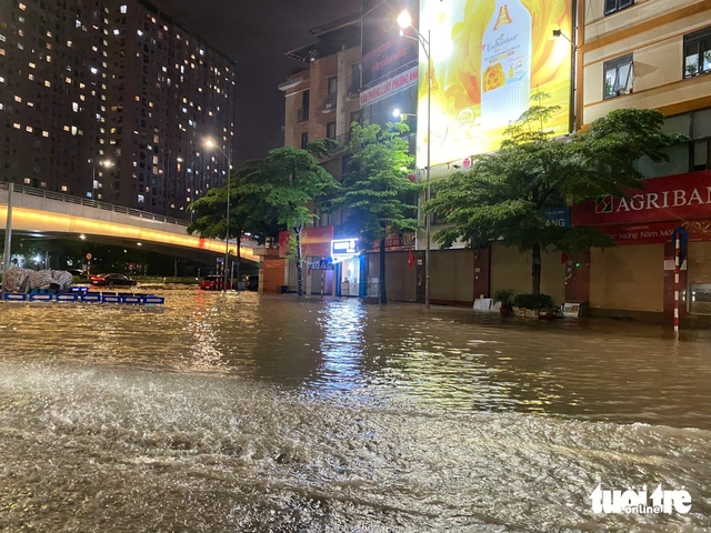 Heavy rains flood Hanoi streets again, residents struggle to get home - Ảnh 3.