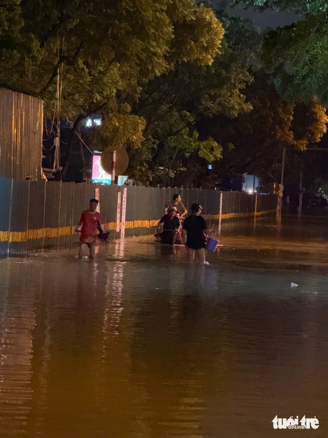 Heavy rains flood Hanoi streets again, residents struggle to get home - Ảnh 9.