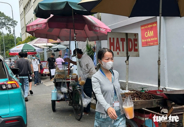 Street vendors overrun sidewalks around major hospitals in Ho Chi Minh City- Ảnh 2.