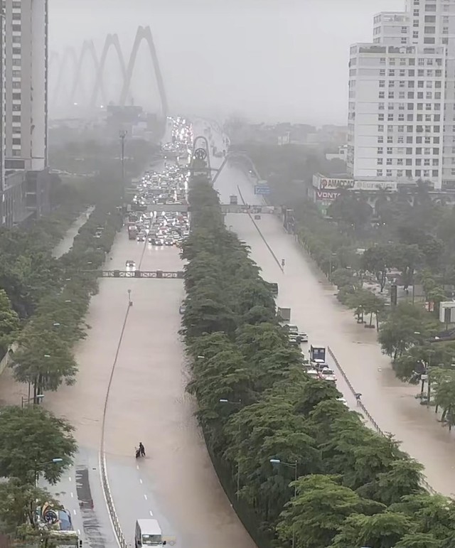 Heavy rain floods Hanoi streets, disrupts traffic, schools - Ảnh 15.