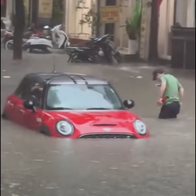 Heavy rain floods Hanoi streets, disrupts traffic, schools - Ảnh 12.