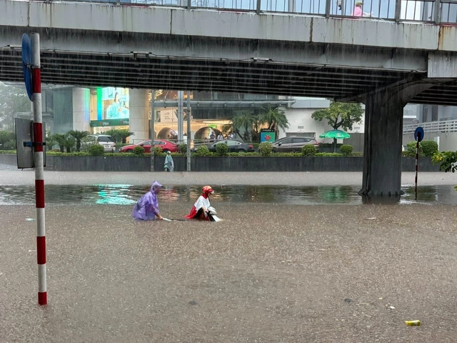 Heavy rain floods Hanoi streets, disrupts traffic, schools - Ảnh 11.