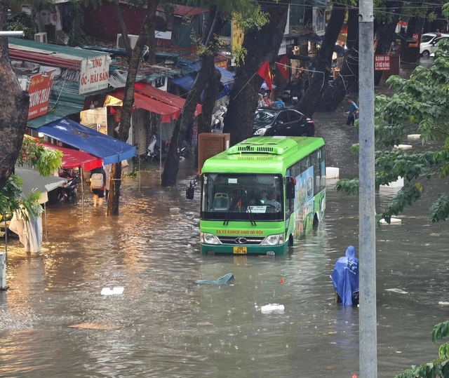 Heavy rain floods Hanoi streets, disrupts traffic, schools - Ảnh 6.