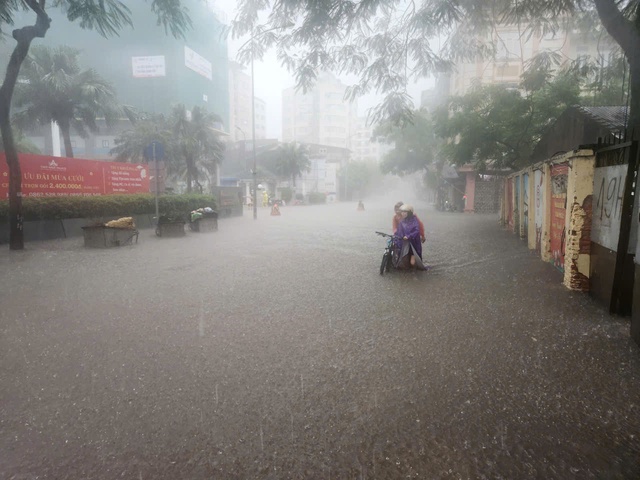 Heavy rain floods Hanoi streets, disrupts traffic, schools - Ảnh 14.