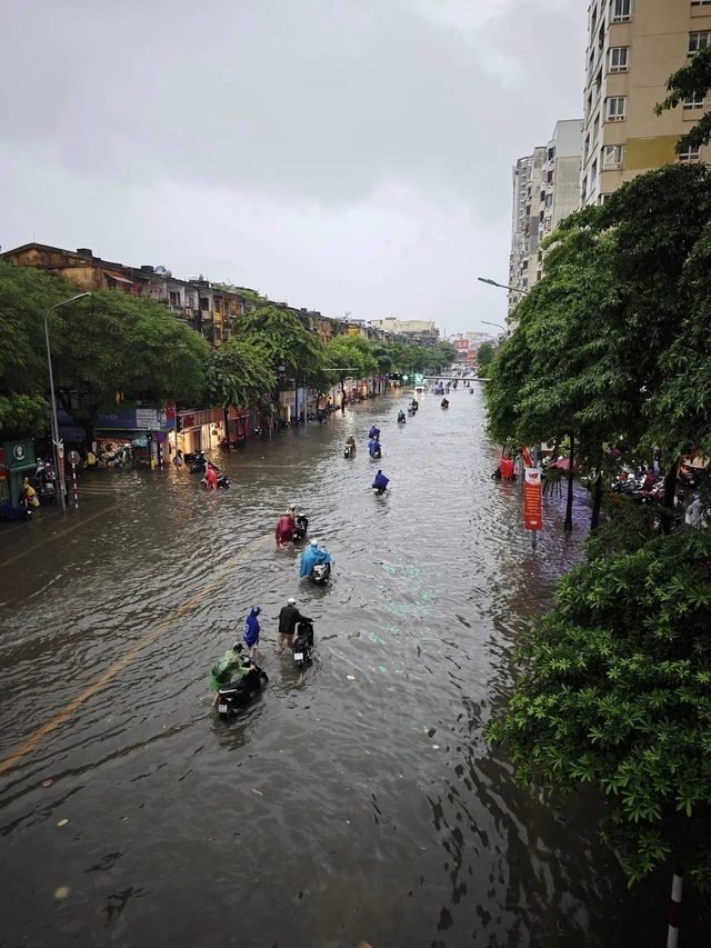 Heavy rain floods Hanoi streets, disrupts traffic, schools - Ảnh 13.