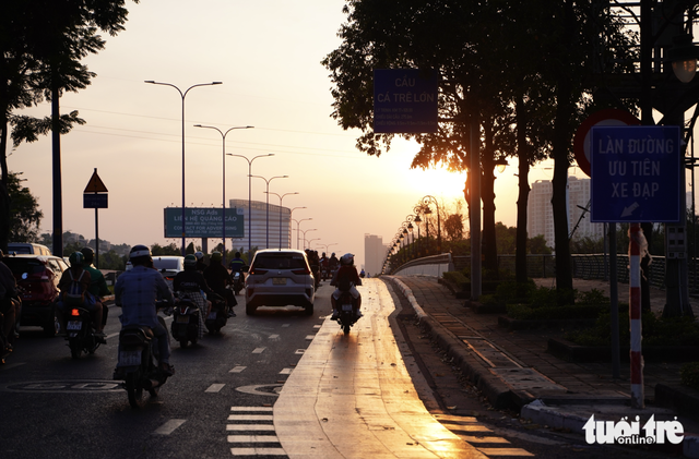 Motorbikes encroach on bicycle lane along Mai Chi Tho Boulevard in Ho Chi Minh City  - Ảnh 2.