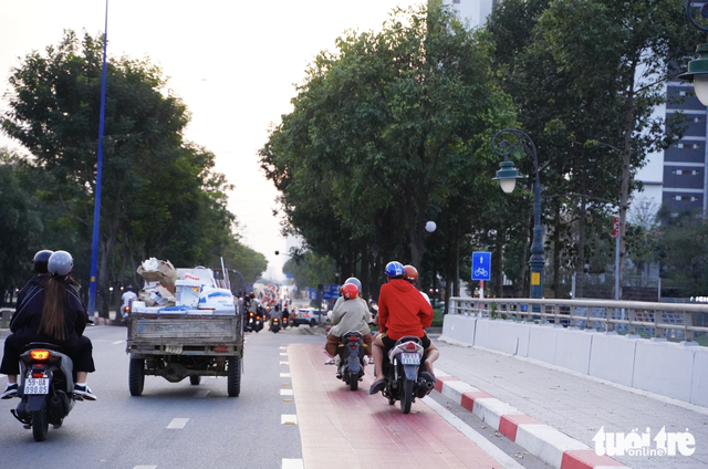 Motorbikes encroach on bicycle lane along Mai Chi Tho Boulevard in Ho Chi Minh City  - Ảnh 3.