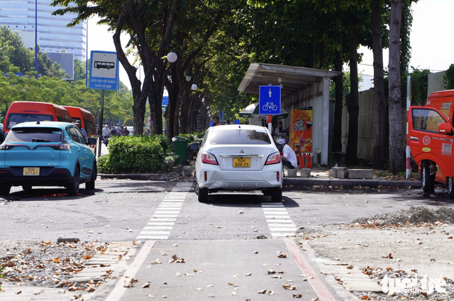 Motorbikes encroach on bicycle lane along Mai Chi Tho Boulevard in Ho Chi Minh City  - Ảnh 4.