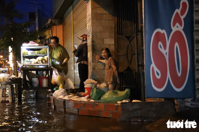 Peak high tides flood Ho Chi Minh City at dawn- Ảnh 1.