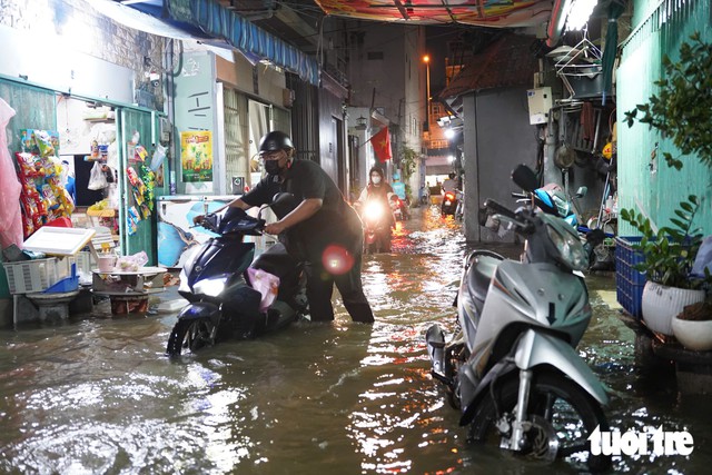High tides flood streets and homes across Ho Chi Minh City - Ảnh 12.