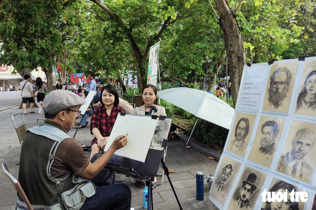 Iconic Hanoi lake’s portrait artists suspend activities, evoking sense of loss among locals - Ảnh 1.