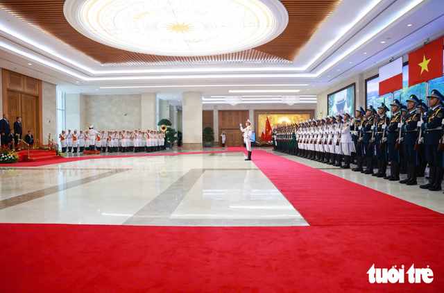 PM Le Minh Hung hosts welcome ceremony for Polish counterpart - Ảnh 1.