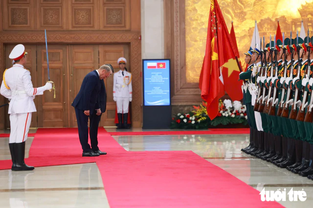 PM Le Minh Hung hosts welcome ceremony for Polish counterpart - Ảnh 3.