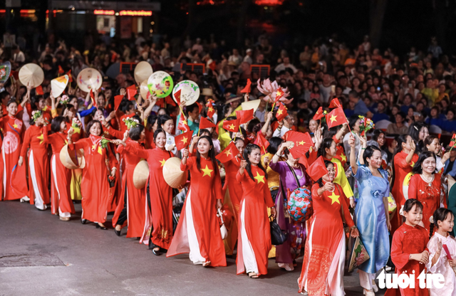 Vietnamese, foreigners in traditional costumes bring Hanoi streets to life- Ảnh 1.