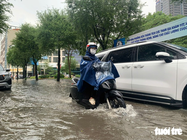 Ho Chi Minh City’s ‘backpacker street’, other downtown streets flooded after heavy midday downpour - Ảnh 1.