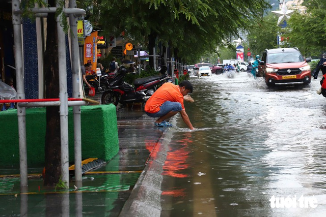 Ho Chi Minh City’s ‘backpacker street’, other downtown streets flooded after heavy midday downpour - Ảnh 4.