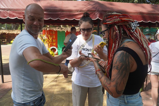 Foreign tourists embrace snakes for photos at snake farm in Vietnam’s Dong Thap - Ảnh 1.