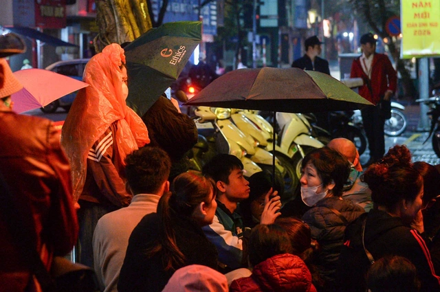 Vietnamese line up in rain to buy gold ahead of God of Wealth Day- Ảnh 1.