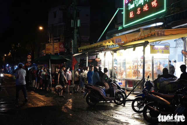 Charcoal burns overnight as vendors prepare grilled snakehead fish for God of Wealth Day in Ho Chi Minh City- Ảnh 8.
