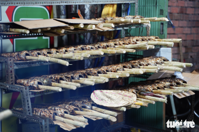 Charcoal burns overnight as vendors prepare grilled snakehead fish for God of Wealth Day in Ho Chi Minh City- Ảnh 2.