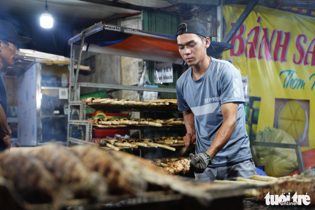 Charcoal burns overnight as vendors prepare grilled snakehead fish for God of Wealth Day in Ho Chi Minh City- Ảnh 3.