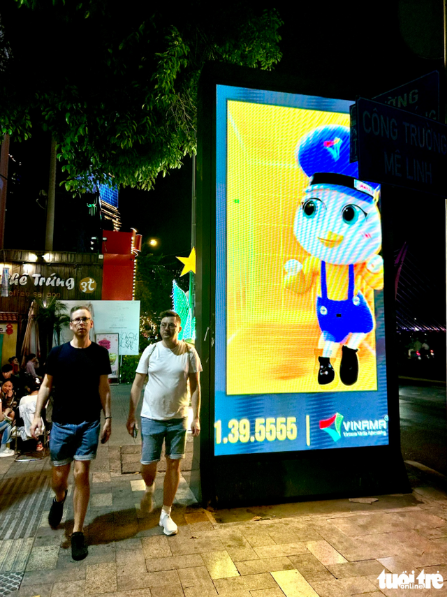 Businesses in Ho Chi Minh City remove illegal sidewalk ads amid crackdown - Ảnh 2.