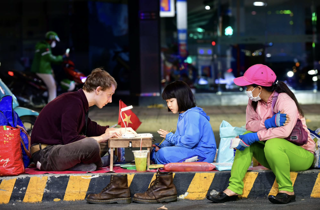 Sidewalk lessons between foreigner and child light up Ho Chi Minh City street- Ảnh 1.