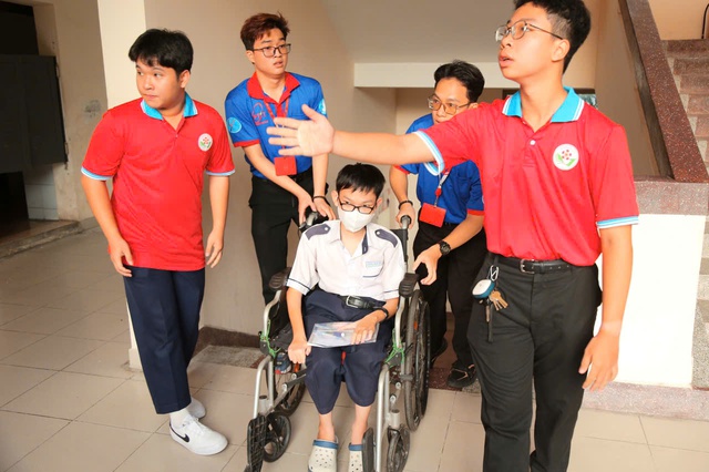Gặp khó khăn khi đi lại, một sĩ tử được các tình nguyện viên nâng xe lăn lên cầu thang- Ảnh 4. Gặp khó khăn khi đi lại, một sĩ tử được các tình nguyện viên nâng xe lăn lên cầu thang- Ảnh 4.