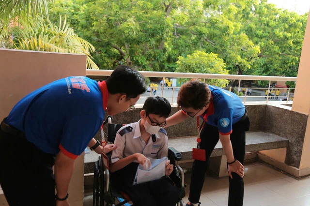 Gặp khó khăn khi đi lại, một sĩ tử được các tình nguyện viên nâng xe lăn lên cầu thang- Ảnh 5. Gặp khó khăn khi đi lại, một sĩ tử được các tình nguyện viên nâng xe lăn lên cầu thang- Ảnh 5.