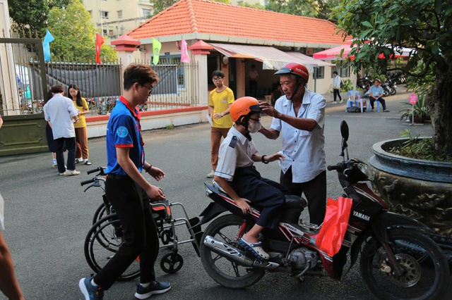 Gặp khó khăn khi đi lại, một sĩ tử được các tình nguyện viên nâng xe lăn lên cầu thang- Ảnh 1. Gặp khó khăn khi đi lại, một sĩ tử được các tình nguyện viên nâng xe lăn lên cầu thang- Ảnh 1.