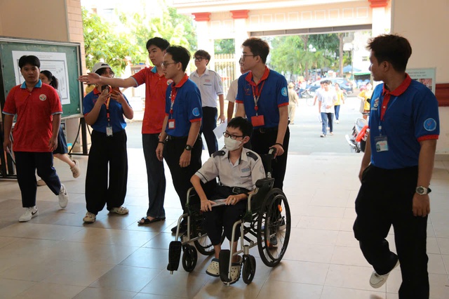 Gặp khó khăn khi đi lại, một sĩ tử được các tình nguyện viên nâng xe lăn lên cầu thang- Ảnh 2. Gặp khó khăn khi đi lại, một sĩ tử được các tình nguyện viên nâng xe lăn lên cầu thang- Ảnh 2.