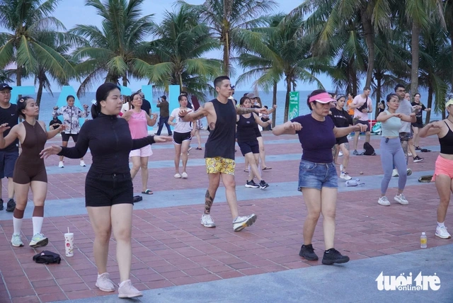 Foreign tourists join lively beachside group dance sessions in Vietnam’s Da Nang - Ảnh 1.