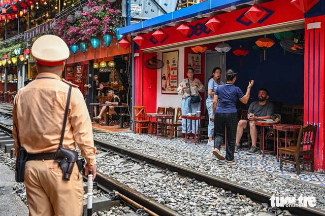 Video: Woman has phone knocked away by train in Hanoi’s ‘train street’ - Ảnh 2.