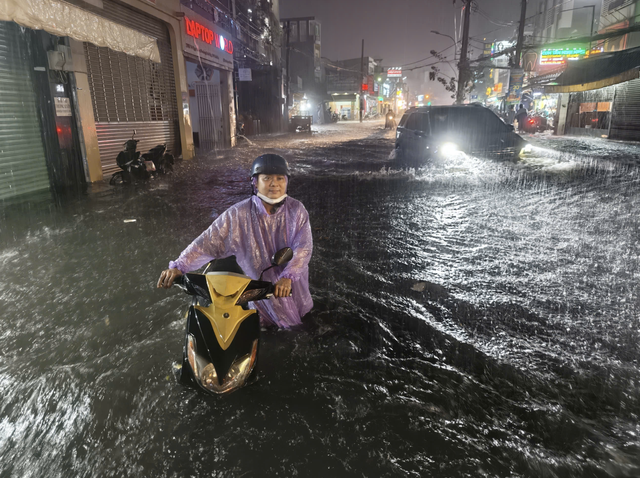 Heavy rain floods streets, disrupts evening commute in Ho Chi Minh City- Ảnh 1.