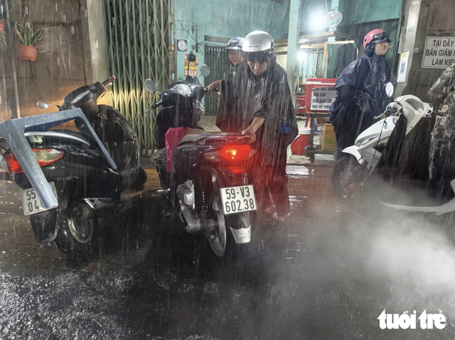 Heavy rain floods streets, disrupts evening commute in Ho Chi Minh City- Ảnh 2.