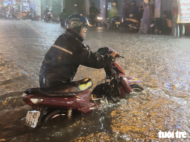 Heavy rain floods streets, disrupts evening commute in Ho Chi Minh City- Ảnh 3.