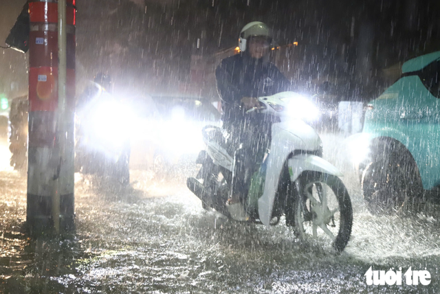Heavy rain floods streets, disrupts evening commute in Ho Chi Minh City- Ảnh 6.