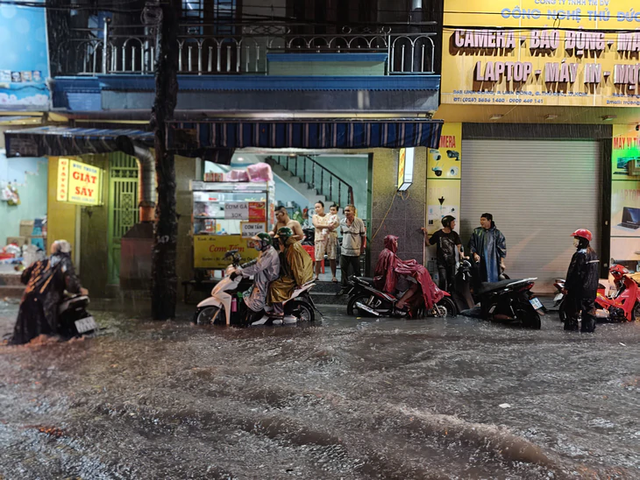 Heavy rain turns streets into torrents, knocks motorcyclists down in Ho Chi Minh City - Ảnh 9.